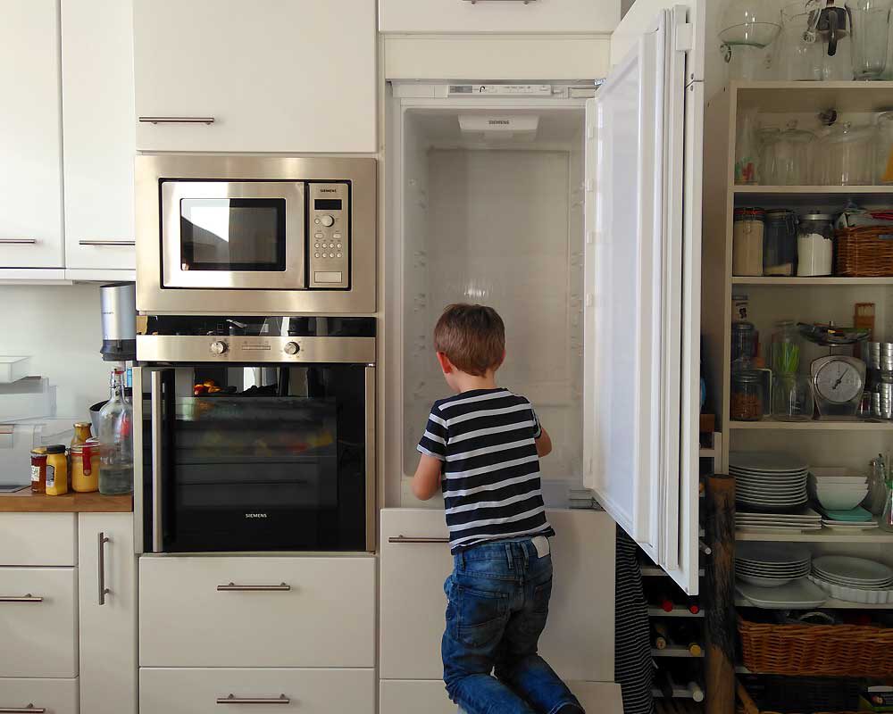 Junge hilft beim Kühlschrank säubern